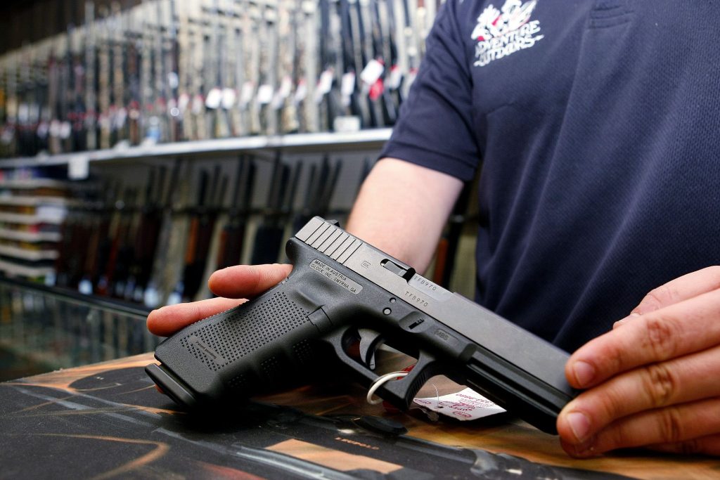 a person showing a handgun in his hands at the store
