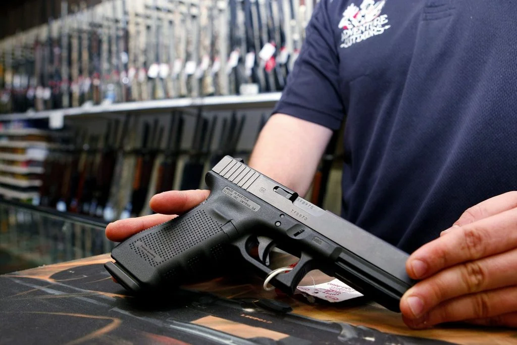 a person showing a handgun in his hands at the store
